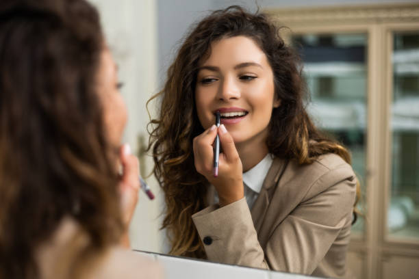 istock Woman applying lipstick 1256671986