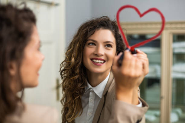 frau zeichnung herz mit lippenstift auf dem spiegel - liebesgruß stock-fotos und bilder