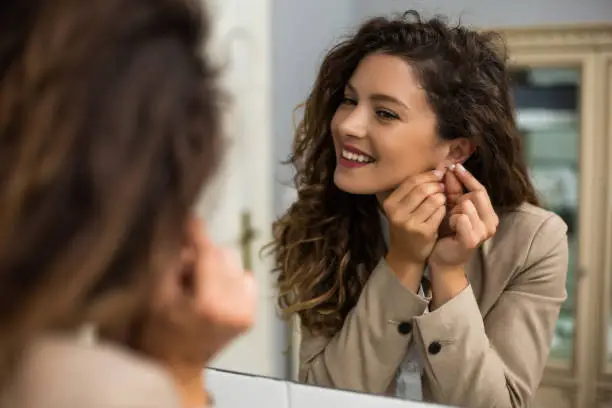 Photo of Woman putting earrings