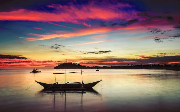 istock Sunset and Boat in Silhouette 1256673968
