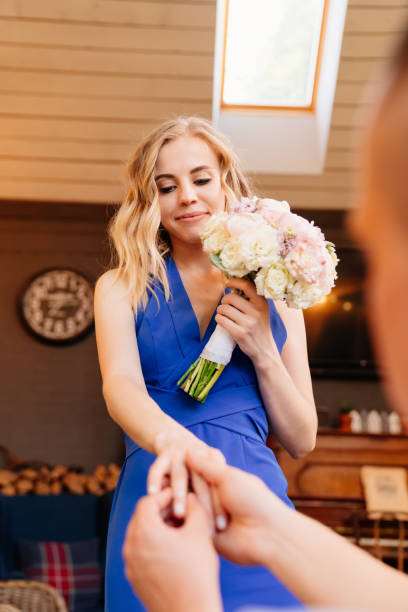 istock man putting engagement ring on finger girl. 1256673973