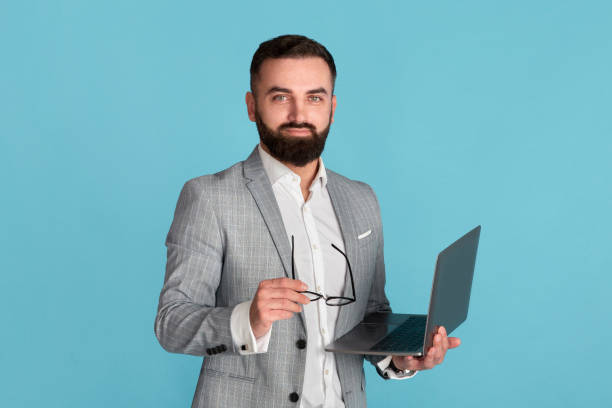istock Online work, education or communication. Confident corporate employee with laptop computer on blue background 1256674481