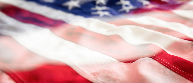 Close up of a red, white and blue American flag with stars and strips unfurled in the wind.