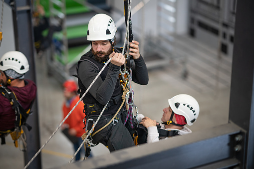 Via ferrata set with coloured carabiners hangs on a wire rope on a rocky mountain. close up