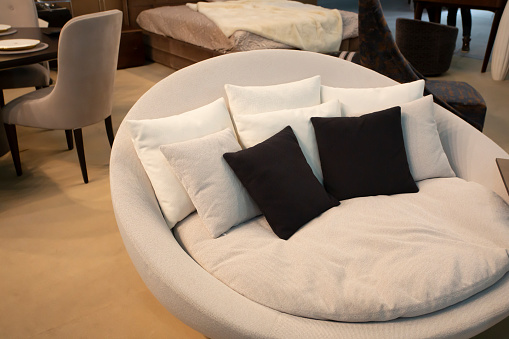 Round comfortable sofa with black pillows