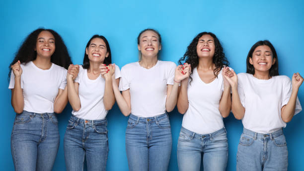 istock Diverse Women Making Wish Holding Hands On Blue Studio Background 1256675792