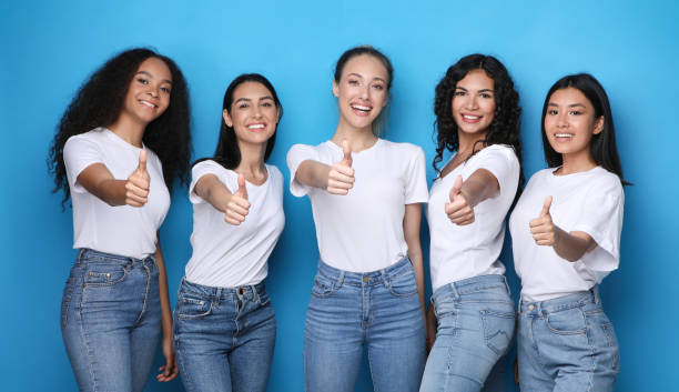 istock Multiracial Ladies Gesturing Thumbs-Up Posing In Studio On Blue Background 1256675823