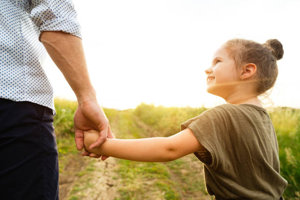 istock Dad taking his little daughter gently by the hand 1256678419