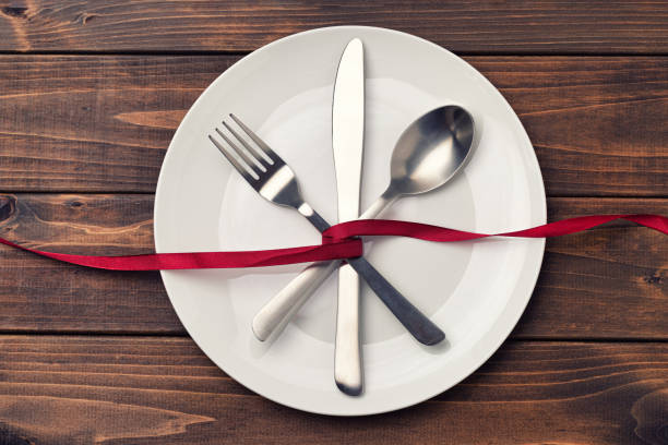 istock Cutlery and ribbon on wood texture background 1256680185
