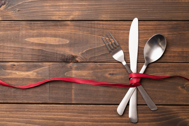 Cutlery and ribbon on wood texture background