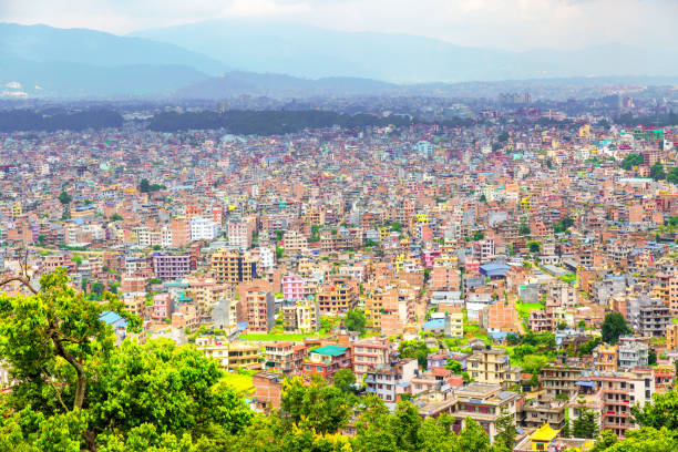 Kathmandu, Nepal: cityscape with densely packed buildings, seen from above - the Nepalese capital  is a densely populated city with a rich history and culture. The city is home to many ancient temples and palaces, as well as bustling markets and modern shopping malls. This image shows a dense area of the city, with buildings, some less than finished, packed close together. Developing countries buildings background.