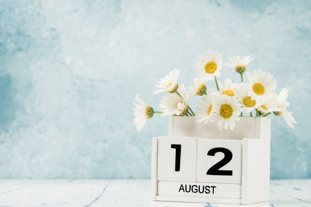 istock White cube calendar for august decorated with daisy flowers 1256680276