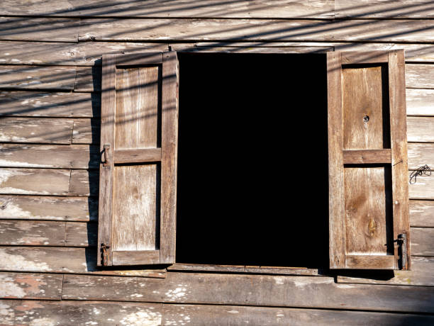 istock Old Native Wooden Wall with Two Open Windows 1256681173