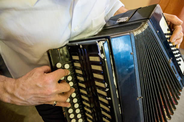 istock a man in a white shirt is playing an old accordion 1256692748