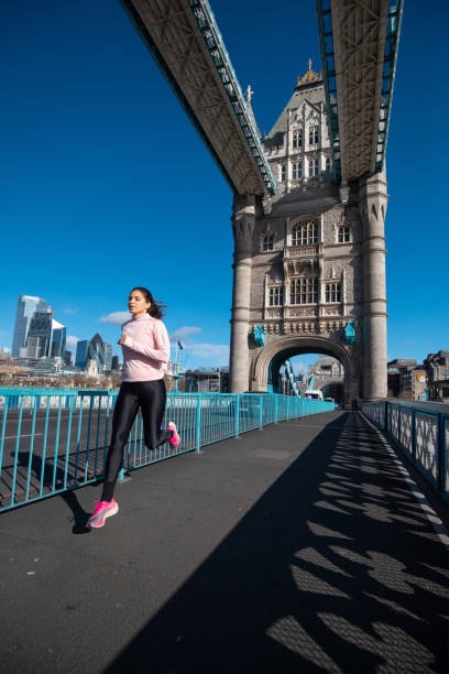 istock Woman jogging across Tower Bridge 1256693995