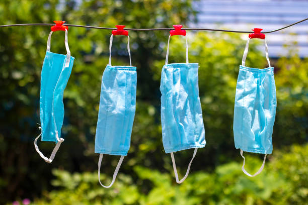 istock selective focus of face masks hanging on an wire after wash. 1256696104