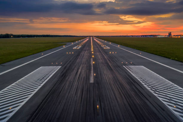 Used concrete asphalt airport empty runway with many braking marks, markings for landings and all navigation lights on pista vacía del aeropuerto de asfalto de hormigón usado con muchas marcas de frenado, marcas para aterrizajes y todas las luces de navegación encendidas. despejado para el aterrizaje de avión comercial o despegar en el aeropuerto de breslavia