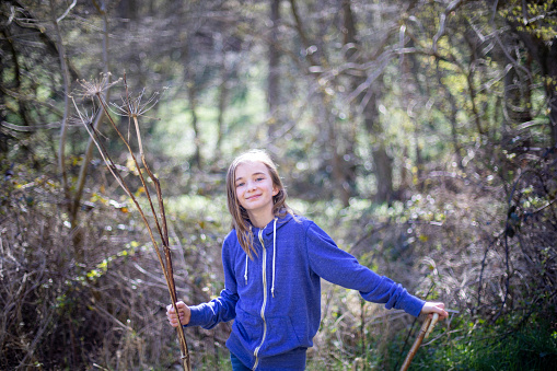 A shot of a young, Caucasian girl walking through woodland in a forest in Northumberland, Northeastern England.