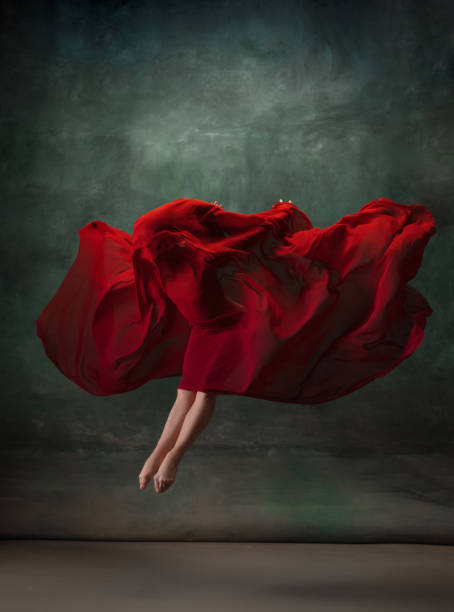 istock Young graceful tender ballerina on dark green studio background 1256699862