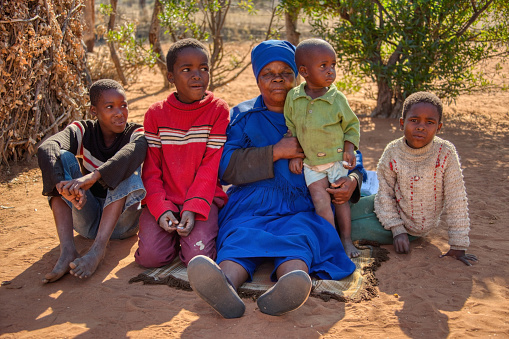 granny and kids, African family, sited in the yard of a village in Botswana
