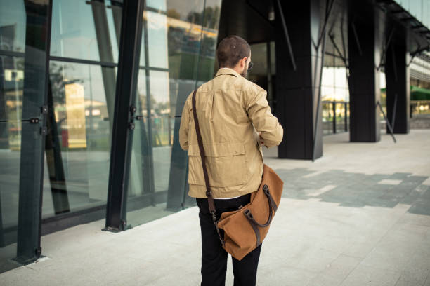 istock Modern hipster riding skateboard on his way to work 1256701215