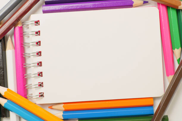 istock Colored pencils and notepads on a white background 1256701622