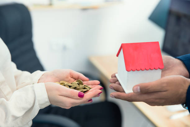 istock couple hand house model and coins 1256706410