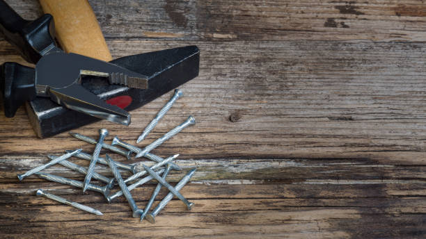 istock Used wooden workshop table with hammer, pliers and nails 1256712878