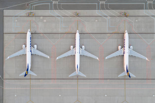 Drone top down view on Ryanair airplane in the parking lot of the airport apron. Photo taken from drone Wroclaw, Poland - June 17, 2020: Top down view on Ryanair airplane in the parking lot of the airport apron, waiting for services maintenance, refilling fuel after airspace lock down. Low cost airlines airport aerial view stock pictures, royalty-free photos & images