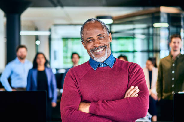istock Mature manager smiling with his diverse design team standing behind him 1256716687