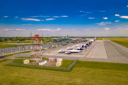 Wroclaw, Poland - June 17, 2020: Airplanes parked on airport apron in front of Wroclaw Airport terminal. Seen from low angle in front airspace radar. Photo taken from the drone