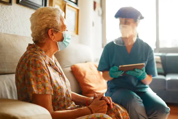Photo of A female doctor visits a senior woman at the nursing home.