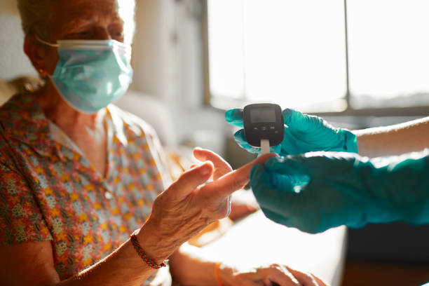 A nurse helping a senior woman perform a diabetes test At home during Lockdown.
Real people in their real environment.
A nurse helping a senior woman perform a diabetes test home caregiver photos stock pictures, royalty-free photos & images