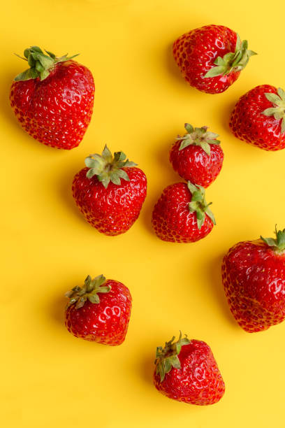 istock strawberries at yellow minimal background 1256719155