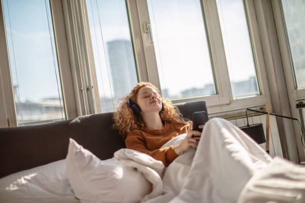 istock Young woman using a mobile phone in bed 1256719772