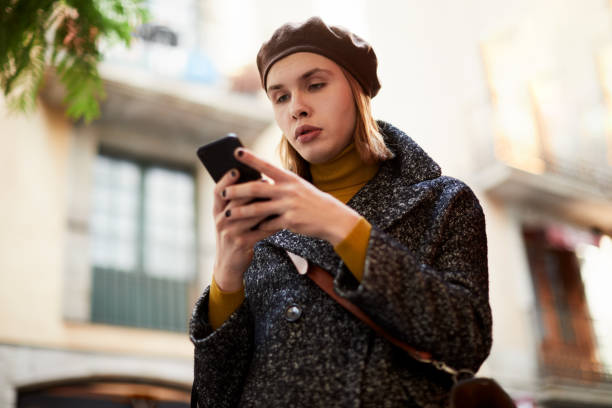 istock Cross dressing man using a smartphone in the street. 1256721071