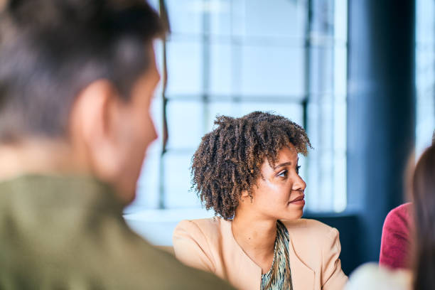 istock Smiling young businesswoman working with colleagues around an office table 1256722725