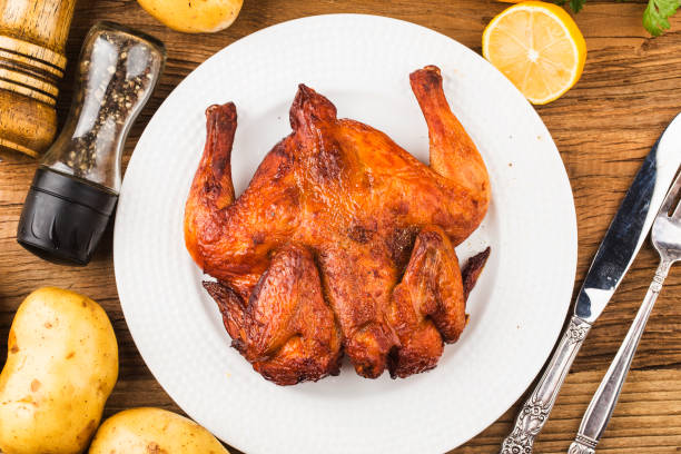 istock Fresh roast chicken on a wooden board background 1256723948