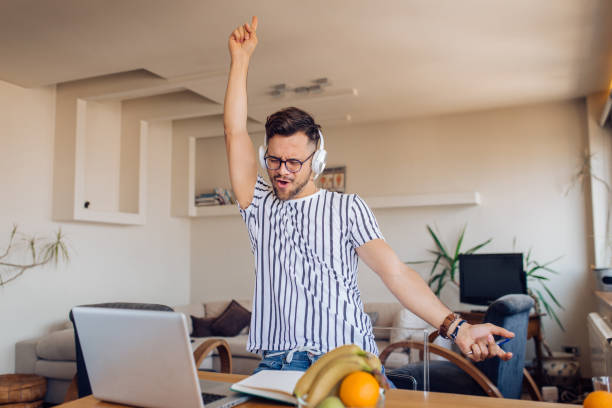 istock Happy young man making his own party at home 1256724145