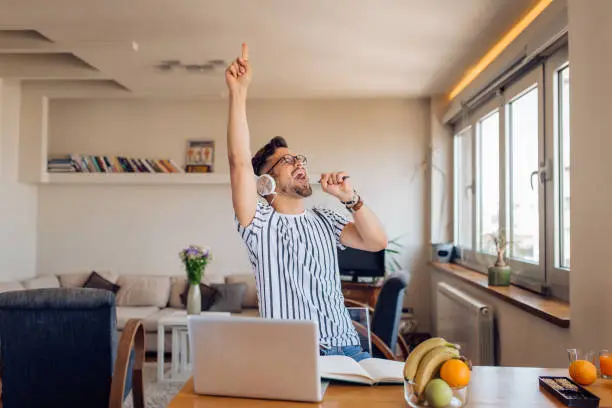 Photo of Excited young man making his own crazy party at home