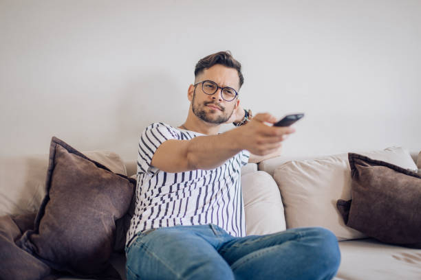 istock Young man watching TV and being bored 1256724251