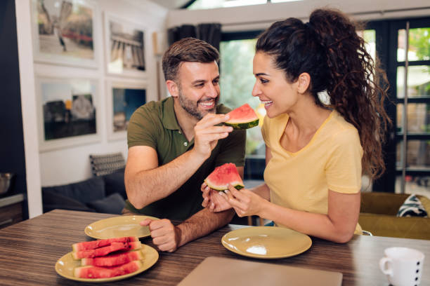 istock Man sharing watermelon with his wife 1256725689