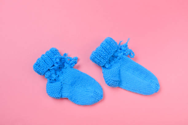istock knitted baby booties on pastel pink background - Image 1256727446