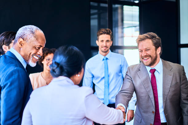 istock Laughing businesspeople shaking hands during a boardroom meeting 1256727505