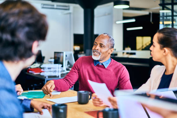 istock Manager meeting with his team around an office table 1256731712