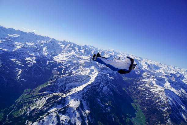 istock Wing suit soars above mountain landscape 1256731726