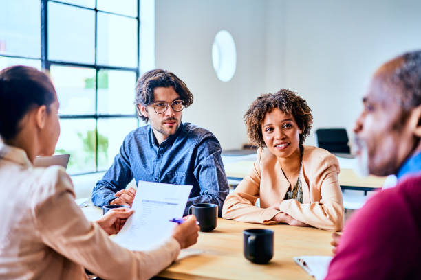 istock Diverse businesspeople discussing work together around an office table 1256731951