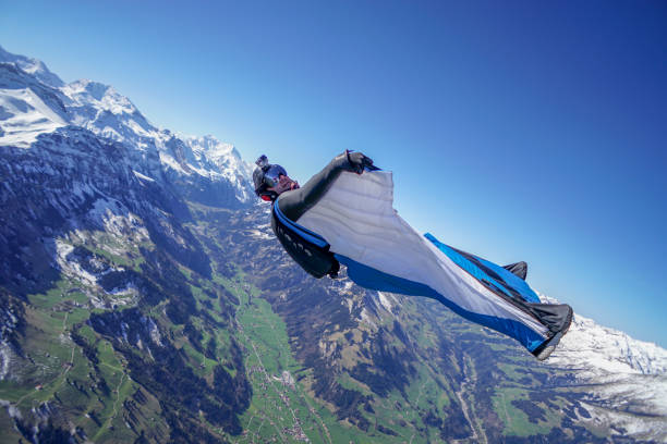 istock Wing suit soars above mountain landscape 1256732248