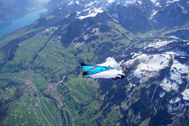 istock Wing suit soars above mountain landscape 1256733028