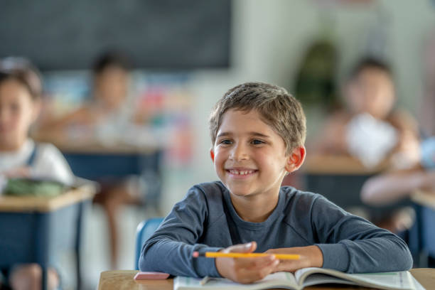 istock Young boy sitting in a classroom 1256733119
